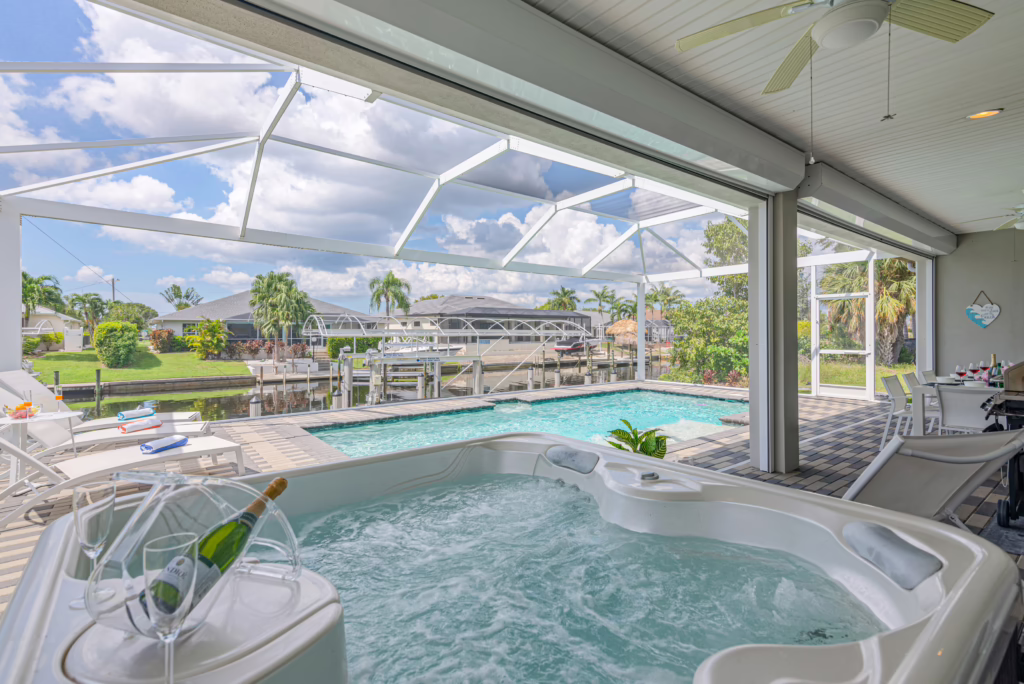 Outdoor area at Villa Dandelion with hot tub, pool, sun loungers, and canal view in Cape Coral.