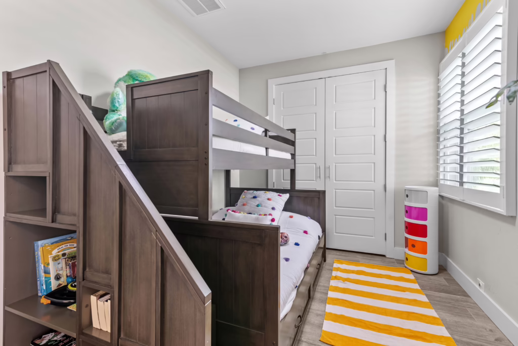 Kids' room at Villa Dandelion with wooden bunk bed, stairs with storage, and colorful accents.