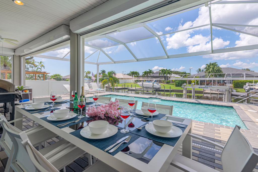 Terrasse der Villa Dandelion mit gedecktem Esstisch, Pool und Blick auf den Kanal in Cape Coral.