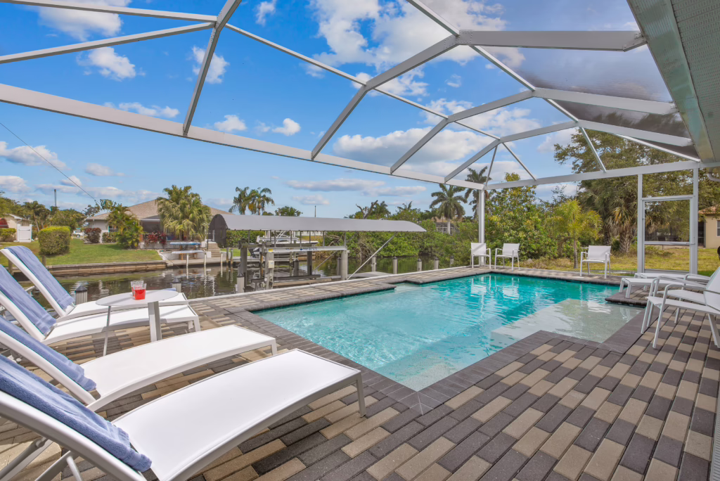 Private screened pool with sun loungers and canal view – Villa Dandelion Cape Coral vacation rental