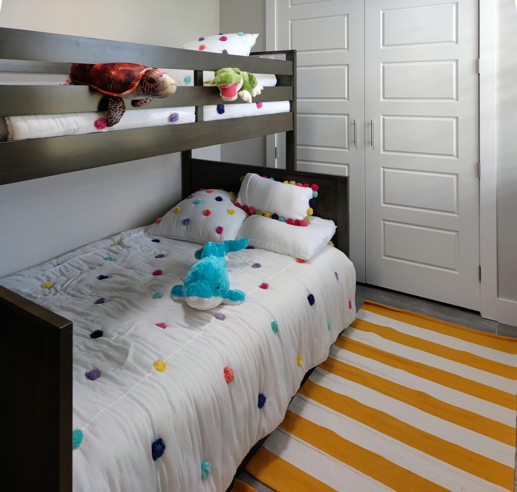 Kids room with wooden bunk bed, colorful bedding and stuffed animals – Villa Dandelion Cape Coral Florida
