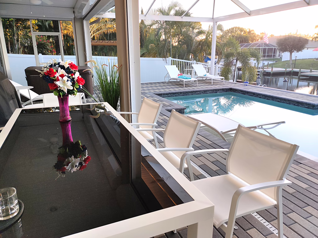 Outdoor dining area with glass table, chairs and private pool – Villa Dandelion Cape Coral Florida